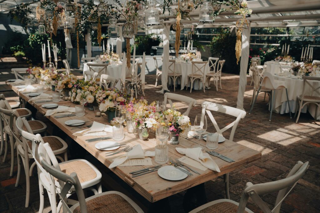 Mesa decorada para banquete de boda con vajilla y centros de mesa