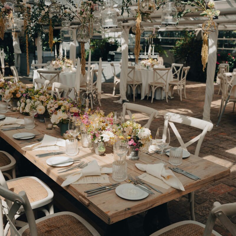 Mesa decorada para banquete de boda con vajilla y centros de mesa